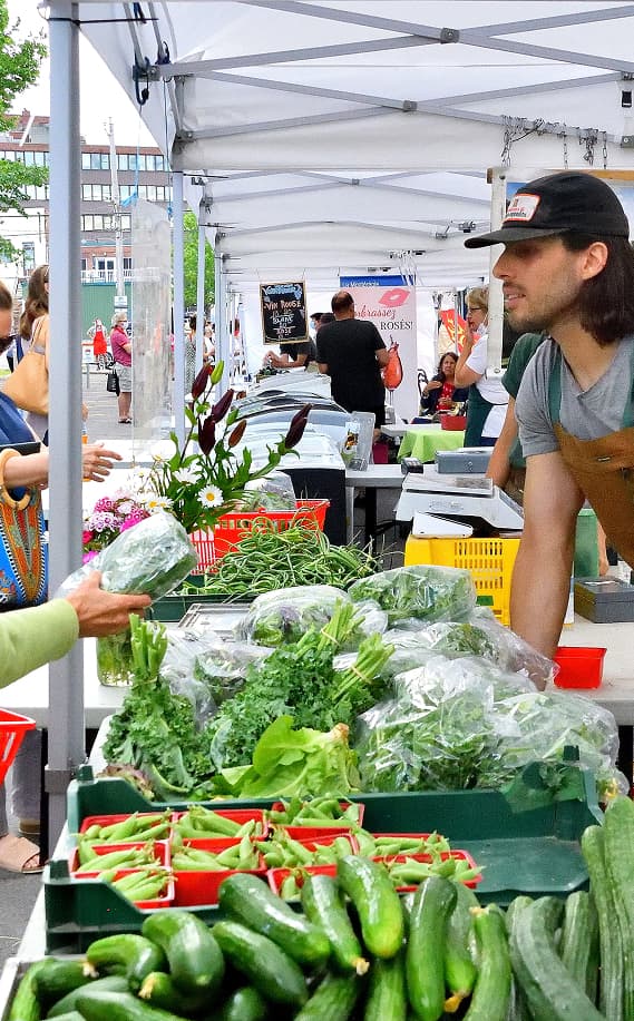 Mickael, un des propriétaire de JDC alors qu'il vent ses légumes à un marché local.